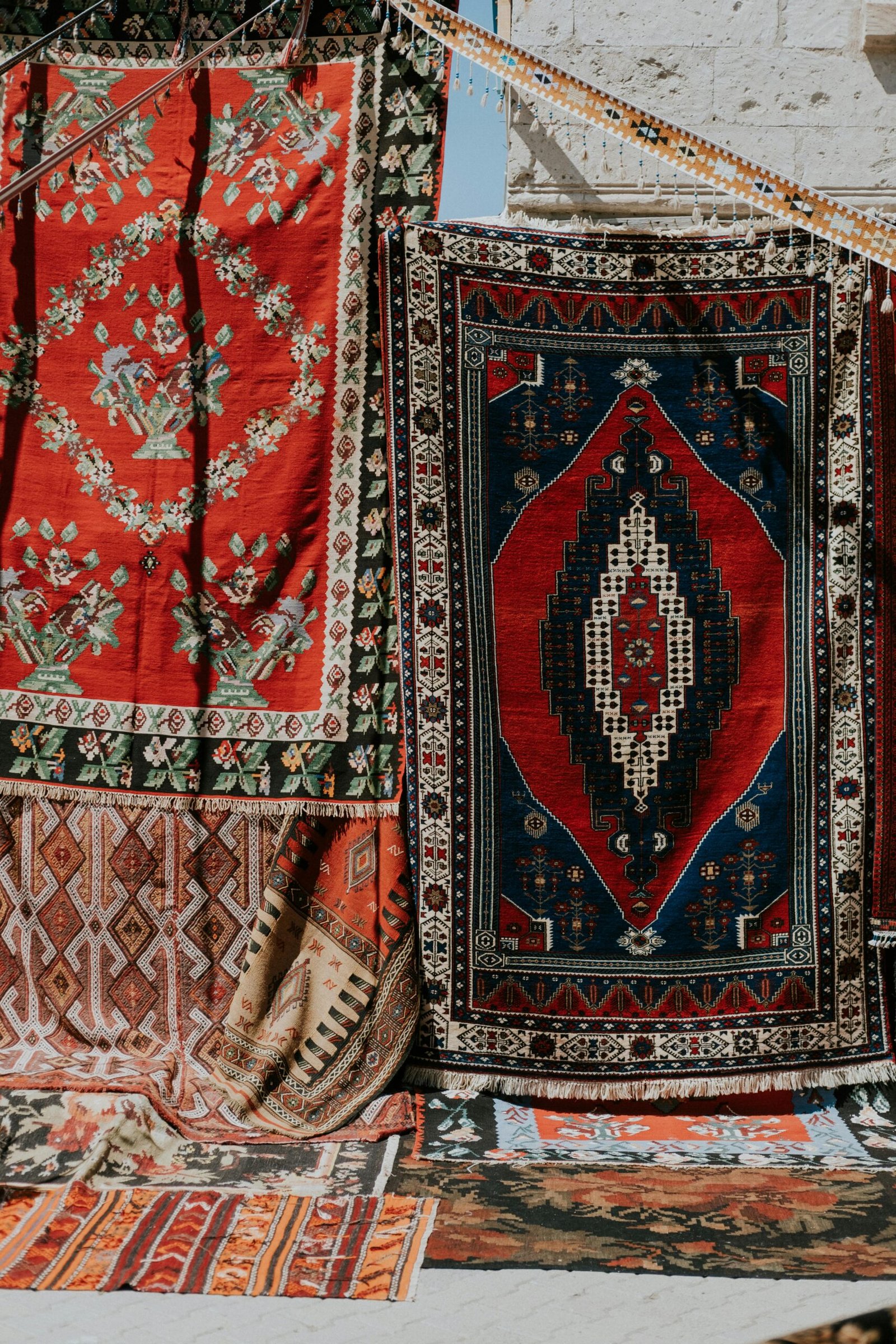 Vibrant display of Turkish rugs hung outdoors, showcasing intricate patterns and colors.